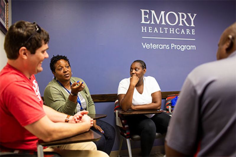 students in front of emory healthcare sign